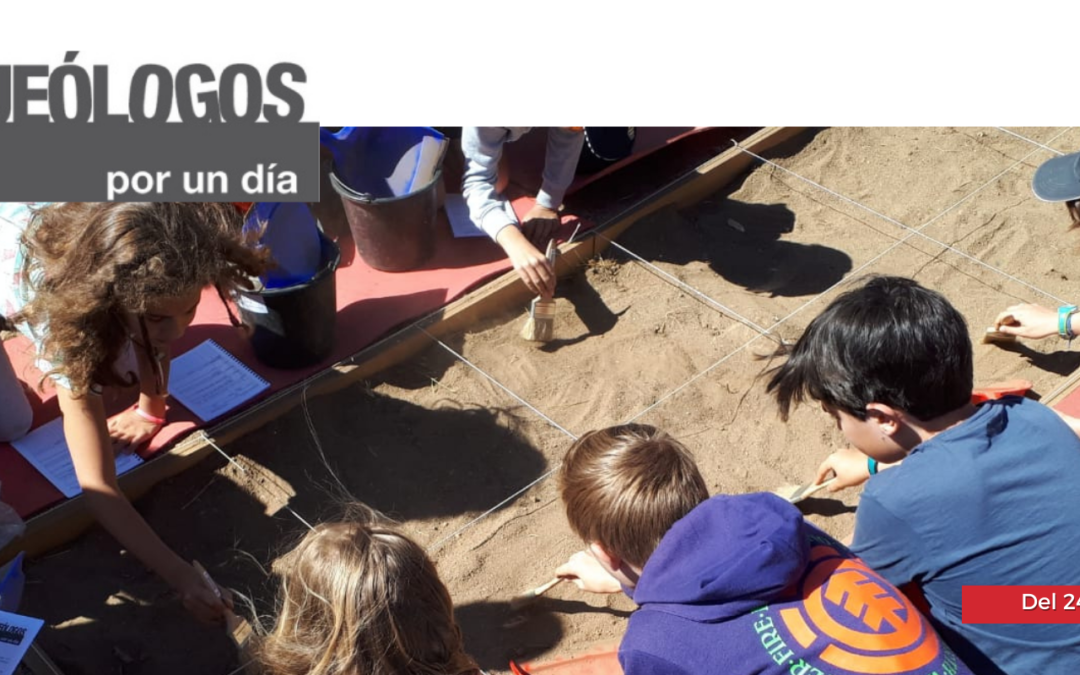 Niños trabajando en una parcela de tierra acotada con los utensilios propios de un arqueólogo