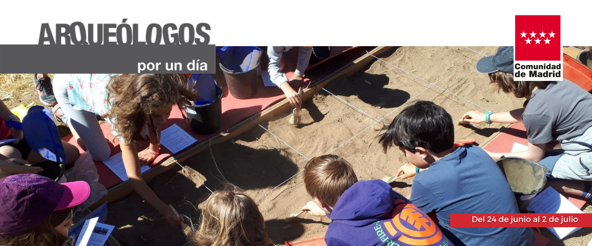 Niños trabajando en una parcela de tierra acotada con los utensilios propios de un arqueólogo